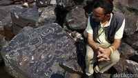 Arkeolog Jaime Oliveira sedang mengamati batuan berukiran wajah di Sungai Amazon yang surut, Sabtu (28/10/2023) lalu.
