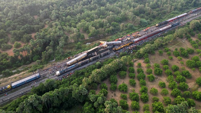 Rescue workers and police officials stand next to damaged coaches following a collision between two passenger trains in Vizianagaram district in the southern Andhra Pradesh state, India, October 30, 2023. REUTERS/R.Narendra NO RESALES. NO ARCHIVES
