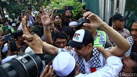 Munarman yang mengenakan syal dan topi Palestina langsung disambut simpatisan saat keluar dari Lapas Salemba. 