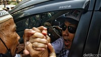 Massa terus berebut bersalaman saat Munarman pergi dengan mobil. 