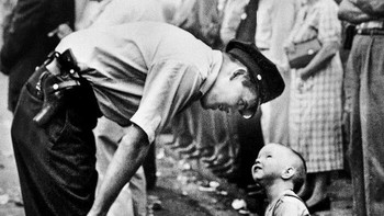 Gambar petugas polisi Maurice Cullinane dan bocah lelaki berusia dua tahun Allen Weaver saat parade di Chinatown, Washington, DC. Polisi telah memperingatkan anak laki-laki tersebut agar tidak terlalu dekat dengan naga, dan saat itulah William C. Beall menangkap percakapan tersebut dalam film dan Dewan Hadiah Pulitzer menyebutnya “gambar menarik yang memberikan kesan mendalam pada pembaca.” Foto: via 121Cliks