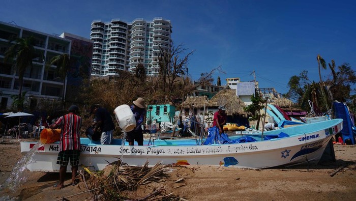 Kapal-kapal di Meksiko Terdampar Usai Terseret Badai Otis Fishermen remove water from a boat in the aftermath of Hurricane Otis in Acapulco, Mexico, October 29, 2023. REUTERS/Alexandre Meneghini