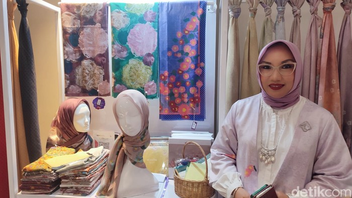 Lita Ridwan Hassan dengan latar scarf bermotif lukisan bunga karya Izzati