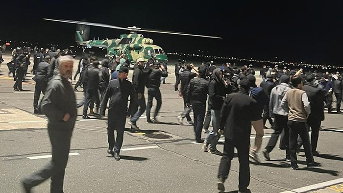 People in the crowd walk shouting antisemitic slogans at an airfield of the airport in Makhachkala, Russia, Monday, Oct. 30, 2023. Russian news agencies and social media say hundreds of people have stormed into the main airport in the Dagestan region and onto the landing field to protest the arrival of an airliner coming from Tel Aviv, Israel. (AP Photo)