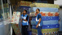 Para pekerja memilah bantuan untuk didistribusikan kepada warga Palestina di Khan Younis di selatan Jalur Gaza, 26 Oktober 2023.  