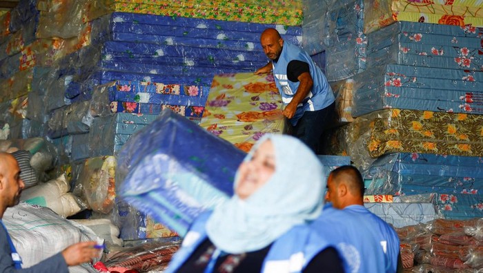 PBB Distribusikan Kasur untuk Korban di Gaza Workers sort aid to be distributed to Palestinians, as the conflict between Israel and Palestinian Islamist group Hamas continues, at a United Nations-run facility, in Khan Younis in the southern Gaza Strip, October 26, 2023. REUTERS/Ibraheem Abu Mustafa
