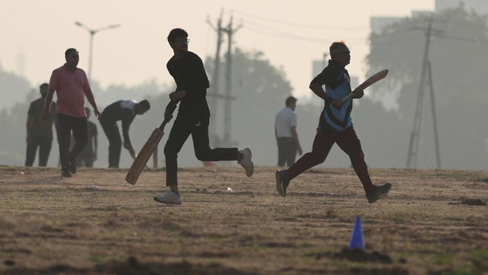 Men play cricket in an open space on the outskirts of Ahmedabad, India, October 29, 2023. REUTERS/Amit Dave