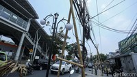 Gulungan-gulungan kabel yang menggantung juga merusak pemandangan di kawasan trotoar tersebut.  