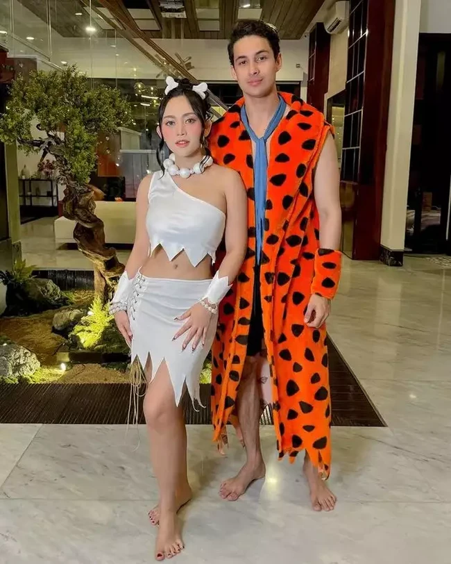 Rachel Vennya bersama kekasihnya, Salim Nauderer kompak menjadi Wilma dan Fred The Flinstone. Rachel tampil seksi mengenakan crop top one shoulder putih dan rok senada, sementara Salim mengenakan jubah oranye khas karakter Fred. Foto: Instagram
