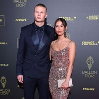 Erling mengenakan setelan tuksedo berwarna navy yang dipadu kemeja dan dasi kupu-kupu berwarna senada. Rambut gondrongnya dikuncir sleek ke belakang. Foto: Pascal Le Segretain/Getty Images