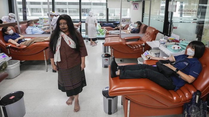A staffer for the National Blood Center dressed in ghost costumes sits next to a blood donor at the center during a Halloween in Bangkok, Thailand, Tuesday, Oct. 31, 2023. The center encourages people to donate their blood in a Halloween-themed campaign. (AP Photo/Sakchai Lalit)