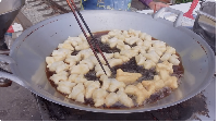 Saat mengunjungi Maeklong Railway Market ini, Jessica Jane kulineran. Ia membeli cakwe sebelum masuk ke area pasar. Foto: YouTube Jessica Jane