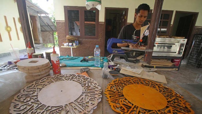 Kerajinan jam dinding kaligrafi Pekerja menjemur kerajinan jam dinding kaligrafi di Kemayoran, Senenan, Bangkalan, Jawa Timur, Selasa (31/10/2023). Kerajinan jam dinding kaligrafi berbahan kayu jati belanda yang dibuat sesuai pesanan tersebut dibanderol dengan harga mulai Rp50.000 hingga Rp600.000 tergantung tingkat kerumitan pembuatannya. ANTARA FOTO/Moch Asim/rwa.