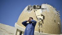 Potret seorang muazin asal Palestina yang mengumandangkan azan di reruntuhan masjid tesebar di media sosial. Diketahui, azan yang dikumandangkan tersebut adalah panggilan untuk salat Jumat.  (Foto: Anadolu Agency via Getty Images)