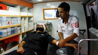 Relawan paramedis Palestina Loay Al-Astal membantu seorang pria di dalam ambulans di Khan Younis, Jalur Gaza, 29 Oktober 2023.  