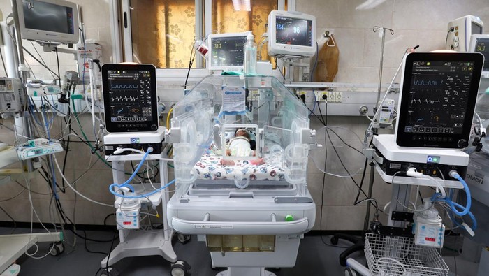 A medical worker assists a premature Palestinian baby who lies in an incubator at the maternity ward of Shifa Hospital, which according to health officials is about to shut down as it runs out of fuel and power, as the conflict between Israel and the Palestinian Islamist group Hamas continues, in Gaza City October 22, 2023. REUTERS/Mohammed Al-Masri