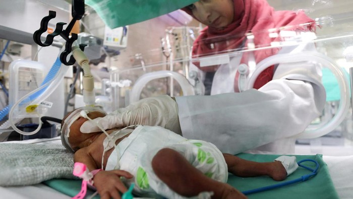 A medical worker assists a premature Palestinian baby who lies in an incubator at the maternity ward of Shifa Hospital, which according to health officials is about to shut down as it runs out of fuel and power, as the conflict between Israel and the Palestinian Islamist group Hamas continues, in Gaza City October 22, 2023. REUTERS/Mohammed Al-Masri