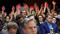 Pengunjuk rasa anti-perang mengangkat tangan mereka yang berdarah ke belakang Menteri Luar Negeri AS Antony Blinken selama sidang Komite Alokasi Senat mengenai permintaan dana tambahan keamanan nasional senilai $106 miliar di Capitol Hill pada Washington, AS, 31 Oktober 2023.  