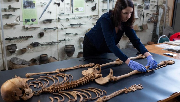 Arkeolog Ungkap Rahasia Pemakaman 'Vampir' di Polandia Professor Dariusz Polinski, the lead archaeologist from Nicolaus Copernicus University, poses with the remains of a woman found at the 17th century cemetery for rejected people in the village of Pien,  in Torun, Poland, October 27, 2023. The woman's body was found with a padlock on her leg and a sickle around the neck which suggest the person was believed to be a 'vampire' and was secured to the ground to avoid 'her rising from the grave'. REUTERS/Lukasz Glowala