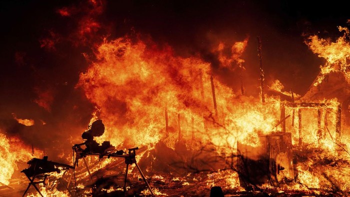 A structure is engulfed in flames as a wildfire called the Highland Fire burns in Aguanga, Calif., Monday, Oct. 30, 2023. A wildfire fueled by gusty Santa Ana winds ripped through rural land southeast of Los Angeles on Monday, forcing thousands of people from their homes, fire authorities said. (AP Photo/Ethan Swope)