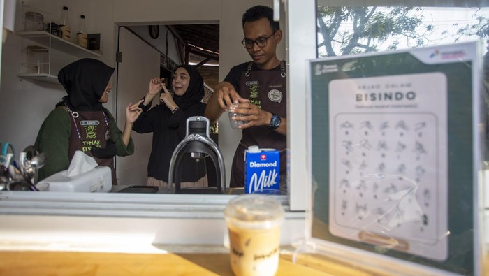 Pembeli memesan kopi menggunakan bahasa isyarat di kedai kopi Sahabat Istimewa di Indramayu, Jawa Barat, Rabu (1/11/2023). Kedai kopi Teman Istimewa binaan PT Kilang Pertamina Internasional (KPI) Balongan tersebut sebagai ruang inkulsi bagi para disabilitas untuk mengembangkan kepercayaan diri dan keahlian dalam berwirausaha. ANTARA FOTO/Dedhez Anggara/foc.