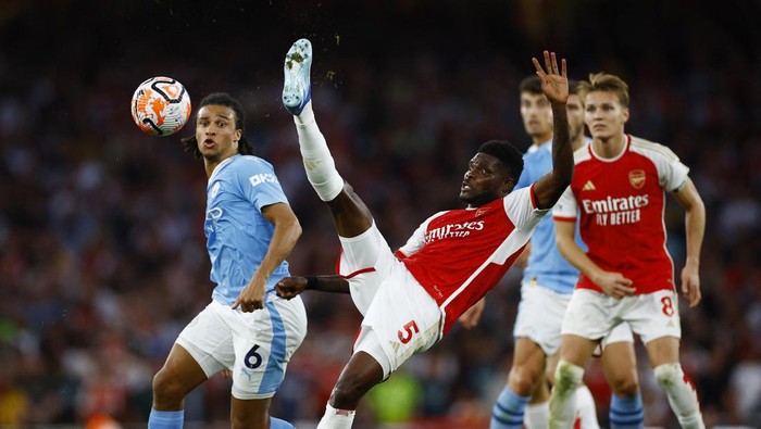 Soccer Football - Premier League - Arsenal v Manchester City - Emirates Stadium, London, Britain - October 8, 2023 Manchester Citys Nathan Ake in action with Arsenals Thomas Partey Action Images via Reuters/John Sibley NO USE WITH UNAUTHORIZED AUDIO, VIDEO, DATA, FIXTURE LISTS, CLUB/LEAGUE LOGOS OR LIVE SERVICES. ONLINE IN-MATCH USE LIMITED TO 45 IMAGES, NO VIDEO EMULATION. NO USE IN BETTING, GAMES OR SINGLE CLUB/LEAGUE/PLAYER PUBLICATIONS.