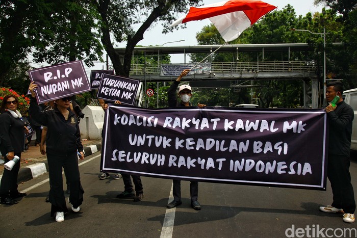Koalisi Rakyat Kawal MK gelar aksi di Patung Kuda, Jakarta, terkait putusan MK soal ambang batas usia capres/cawapres. Mereka membawa spanduk turunkan ketua MK.