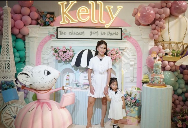 Kezia dan Kelly tampil kompak mengenakan dress berwarna putih. Dress tersebut dipermanis dengan pita hitam kecil di tengah dadanya. Rambut pasangan ibu dan anak itu juga tampak diikat setengah dan diberi hiasan berupa pita hitam. Foto: Instagram/@keziatoemion