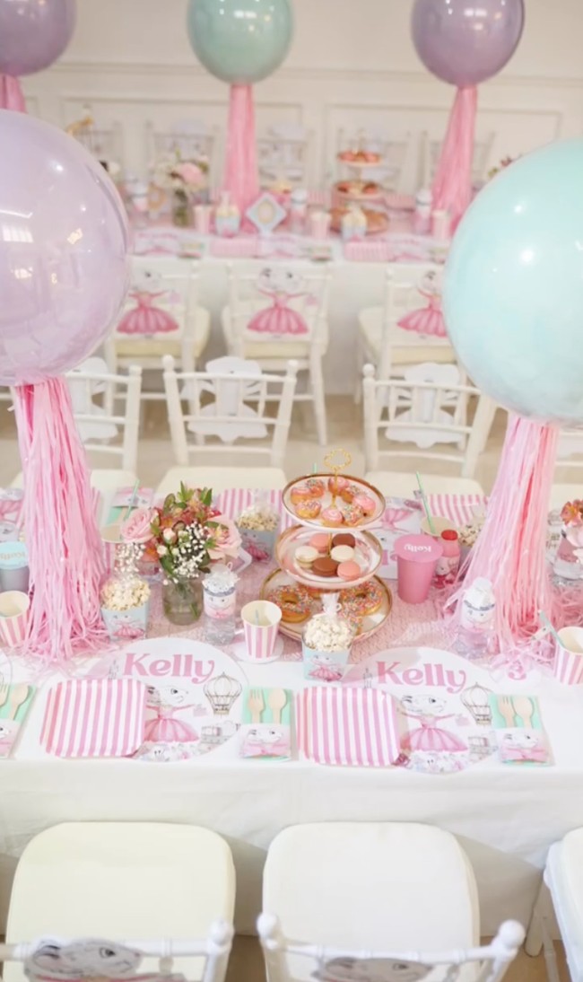 Didominasi oleh warna putih dan merah muda, meja panjang di perayaan ultah Kelly itu tampak sudah didekorasi sedemikian rupa. Terdapat juga balon-balon berwarna pastel yang membuat desainnya semakin cantik. Foto: Instagram/@keziatoemion