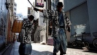 Para pemulung dengan kostum samurai turun ke jalan-jalan di Tokyo pada Rabu (1/11/2023), secara teatrikal menggunakan penjepit sampah dan membuang sisa-sisa sampah dari malam pesta Halloween ke dalam keranjang anyaman di punggung mereka.