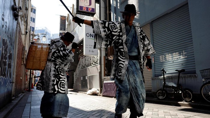 Aksi Samurai Pemulung Bersihkan Jalanan Tokyo Usai Pesta Halloween Keisuke Naka and Ikki Goto, members of Gomihiroi Samurai (trash-picking samurai) clad in denim yukata, poses for a photograph as they pick up trash on the street of Ikebukuro in the morning after Halloween in Tokyo, Japan November 1, 2023. REUTERS/Issei Kato