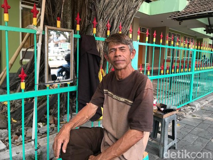 Aminudin atau Udin, yang membuka usaha pangkas rambut di bawah pohon beringin di sekitar Jalan Pangurakan, Ngupasan, Kecamatan Gondomanan, Kota Yogyakarta, saat ditemui Kamis (2/11/2023).
