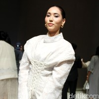 Puteri Indonesia 2022 Laksmi DeNeefe menebar pesonanya dalam padanan blus beraksen korset dengan kerah tinggi dan rok nude senada. (Foto: Mohammad Abduh/detikcom)