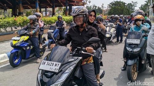 Bupati Lombok Lombok Barat Fauzan Khalid ditemani Isti Khairatun Munzir naik sepeda motor pulang ke kampung halaman diantar ratusan ASN dan relawan, Kamis (2/11/2023). (Ahmad Viqi/detikBali)