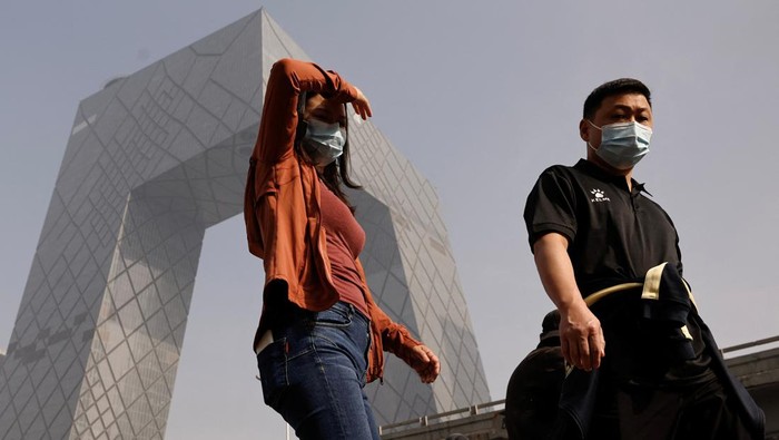 People wearing face masks wait at an intersection in Beijing's Central Business District (CBD), as the city is shrouded in smog, in China November 1, 2023. REUTER/Tingshu Wang