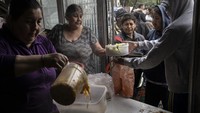 Relawan menyajikan makanan gratis yang diantarkan oleh dapur umum Casa Comunitaria del Fondo di lingkungan berpenghasilan rendah Padre Carlos Mugica di Buenos Aires, Argentina, Rabu (1/11/2023).