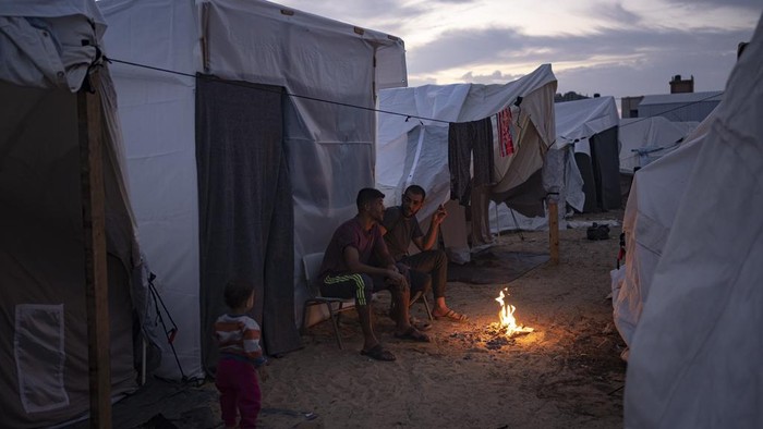 Potret Suasana Pengungsian Warga Palestina Saat Malam Tiba A Palestinian girl who was displaced by the Israeli bombardment of the Gaza Strip walks in a UNDP-provided tent camp in Khan Younis, Wednesday, Nov. 1, 2023. (AP Photo/Fatima Shbair)