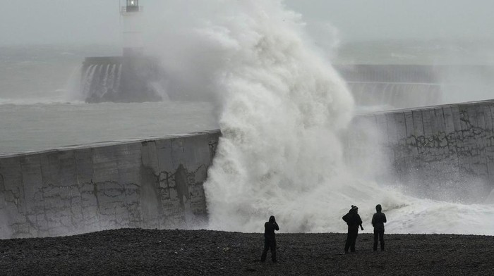 A man takes a photograph as waves crash over Brighton Palace Pier as Storm Ciaran brings high winds and heavy rain along the south coast of England, in Brighton, England, Thursday, Nov. 2, 2023. Winds up to 180 kilometers per hour (108 mph) slammed France's Atlantic coast overnight as Storm Ciaran lashed countries around western Europe, uprooting trees, blowing out windows and leaving 1.2 million French households without electricity Thursday. Strong winds and rain also battered southern England and the Channel Islands, where gusts of more than 160 kph (100 mph) were reported. (AP Photo/Kin Cheung)