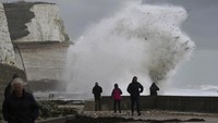 Orang-orang melihat ombak besar yang menerjang wilayah Newhaven, Inggris selatan. (AP Photo/Kin Cheung)  