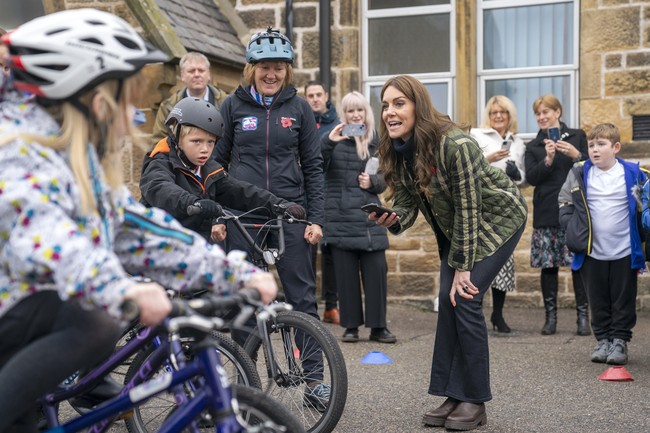 Turut melengkapi gayanya, baju rajut turtleneck, jeans berpotongan bootcut, dan sepasang boots Chelsea dari Reiss. (Foto: Jane Barlow/Pool via AP)