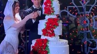 Pernikahan selebriti Kourtney Kardashian dan Travis Barker dirayakan dengan mewah. Tak lupa ada kue bertingkat yang dihias dengan bunga mawar merah yang banyak. Foto: The Knott