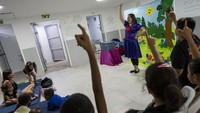 Seorang penghibur menampilkan pertunjukan untuk anak-anak di lingkungan tempat perlindungan bom.