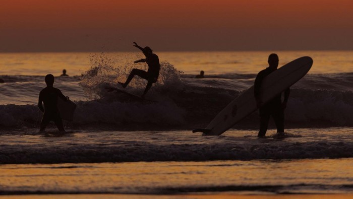 A surfer looks out at the ocean after sunset at Cardiff State Beach in Encinitas, California, U.S.,November 2, 2023. REUTERS/Mike Blake