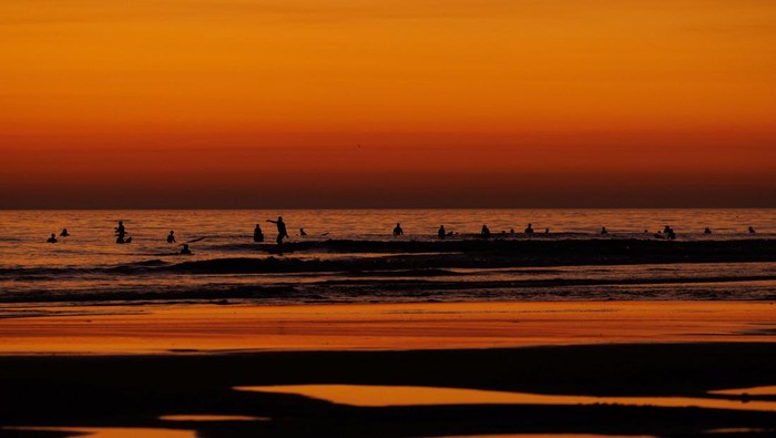 A surfer looks out at the ocean after sunset at Cardiff State Beach in Encinitas, California, U.S.,November 2, 2023.     REUTERS/Mike Blake