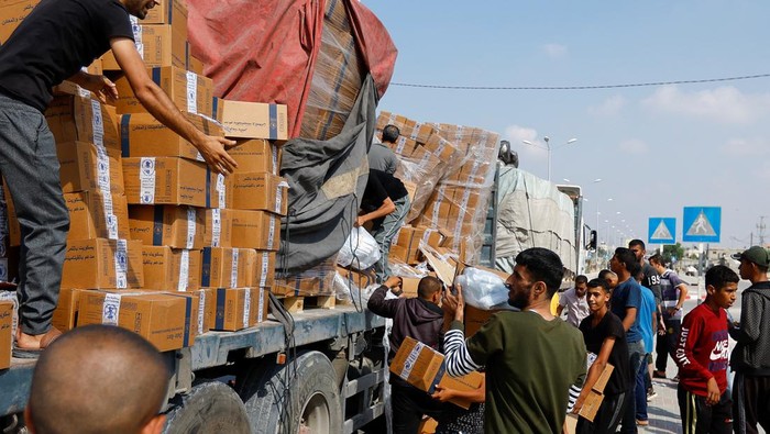 Momen Warga Palestina Bantu Truk Muat Bantuan yang Jatuh di Jalan Palestinians reload a truck with aid that fell from the vehicle, amid shortages of food supplies, during the ongoing conflict between Israel and Palestinian Islamist group Hamas, in Rafah in the southern Gaza Strip, November 2, 2023. REUTERS/Ibraheem Abu Mustafa