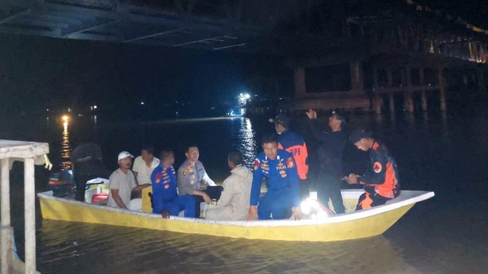 Polisi saat melakukan pencarian korban lakalantas yang masuk ke sungai