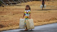 Tampak seorang anak ikut membawa jeriken untuk diisi air saat penyaluran bantuan air bersih di Desa Bontoparang, Kabupaten Takalar.  