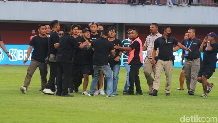 Suporter merangsek masuk ke lapangan.