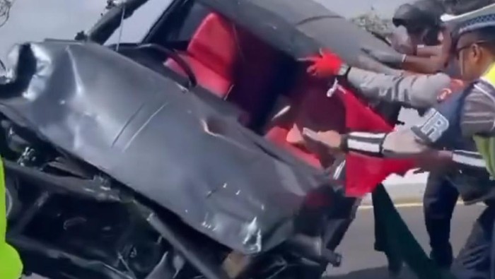 Petugas mengevakuasi mobil Suzuki Jimny terguling di Jalan Tol Bali Mandara. (Tangkapan layar video viral)