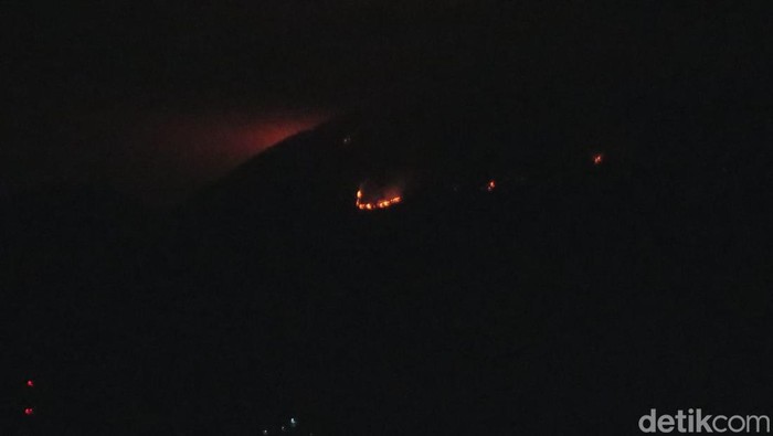 Titik api kebakaran di Gunung Penanggungan masih terlihat membara dari kawasan Krembung, Sidoarjo.